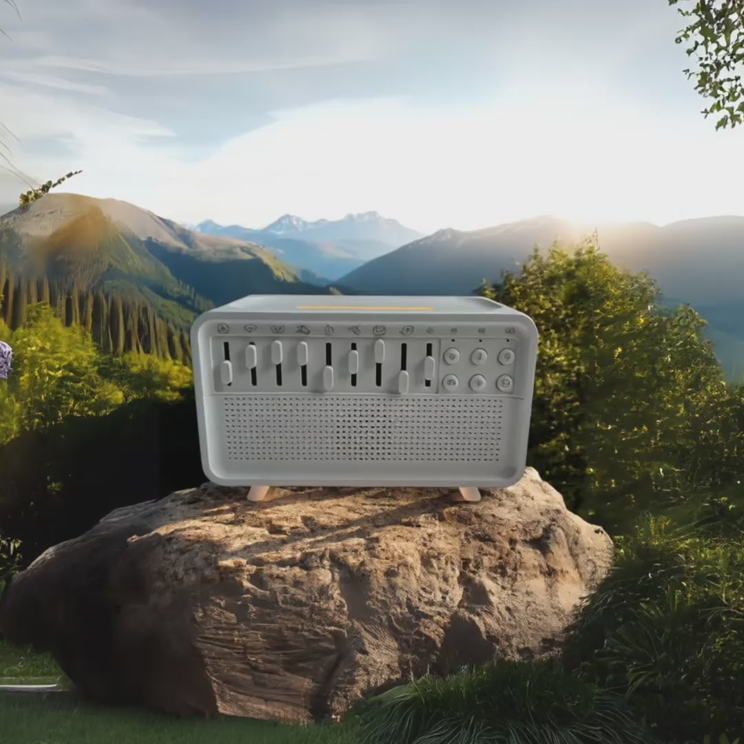 Vidéo du diffuseur sonore CalmBox™ posé sur un rocher au cœur des montagnes, avec un paysage naturel au lever du soleil. Symbolise la connexion à la nature, les sons apaisants (pluie, vent, oiseaux) et le bien-être profond.